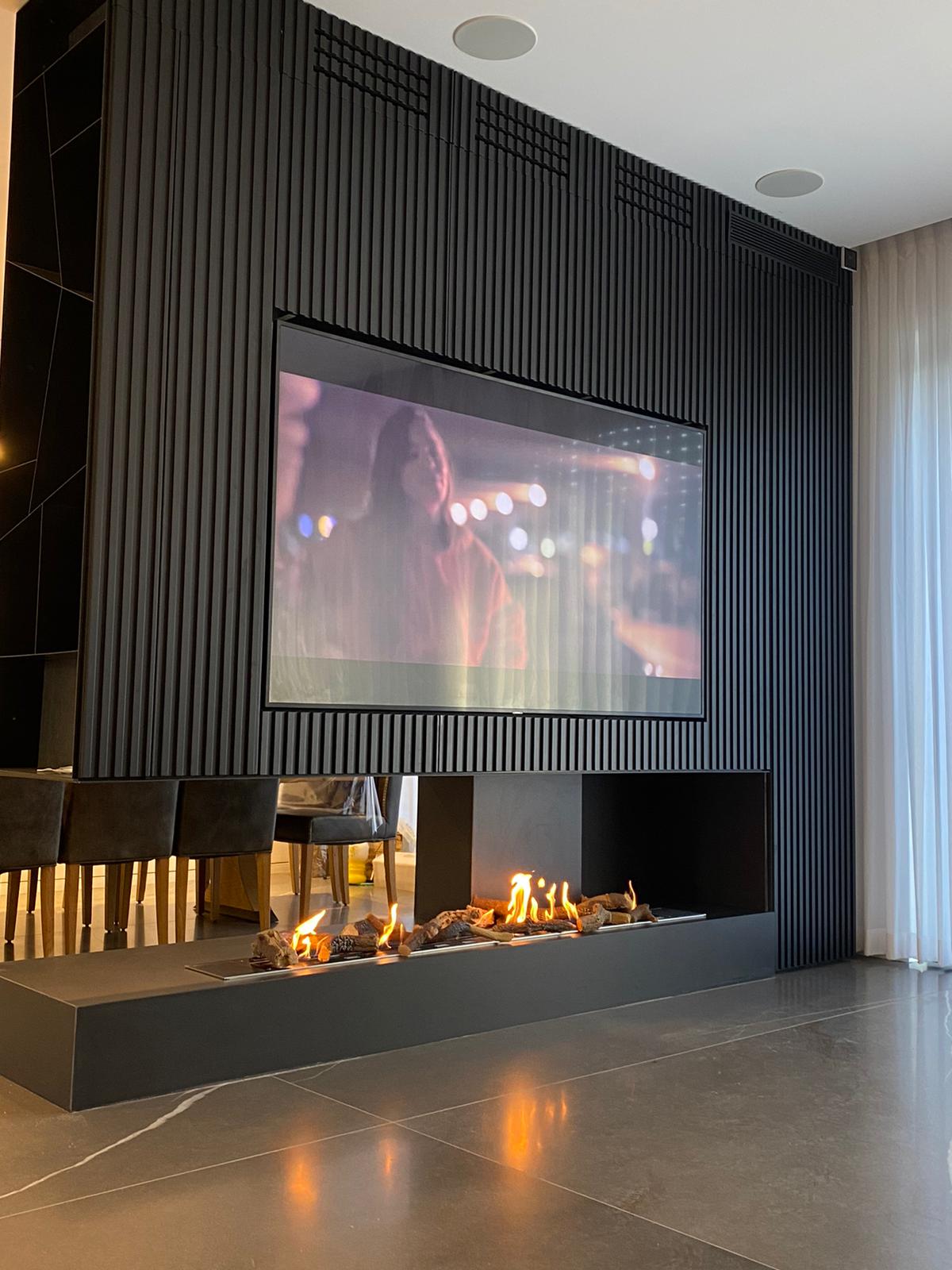 room divider fireplace open on three sides with TV above