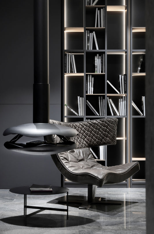 PEROLA Black Contemporary Bioethanol Stove  in modern studio with black leather couch and library in the background.
