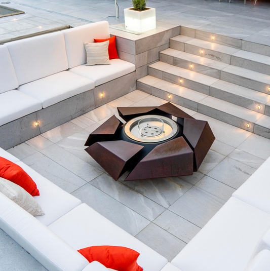 Stravaganza with manual bioethanol burner in rusted corten steel finish in stone-tiled patio with sitting area