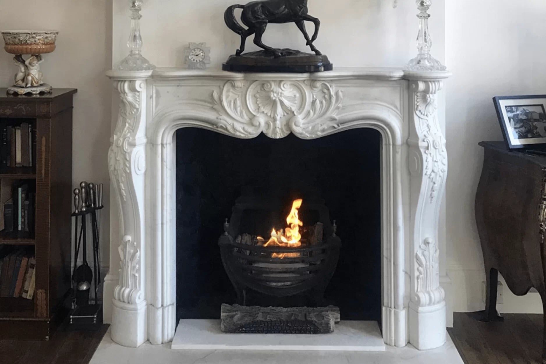 Small Burner in old grate and white stone fireplace