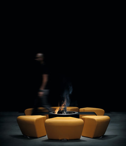 Circus with wood burner and saffron yellow ottomans. Picture at human scale