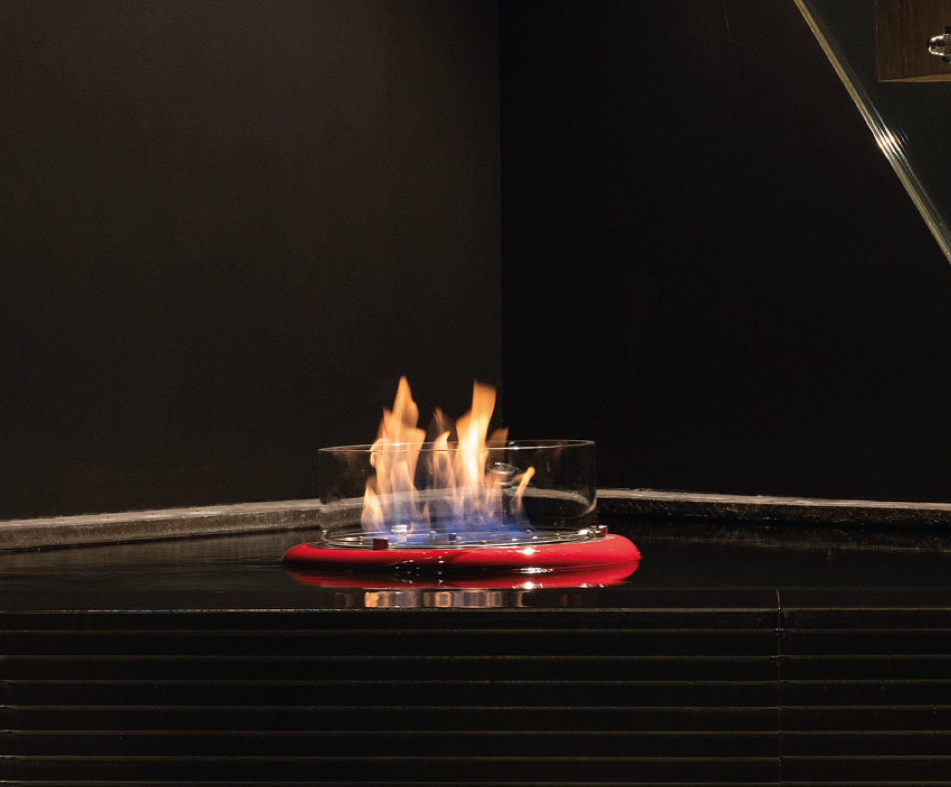 Flut Red Bioethanol fireplace in indoor fish pond.