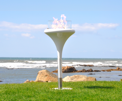 Flut White fixed on the ground in seaside garden with see and rocks in the background.