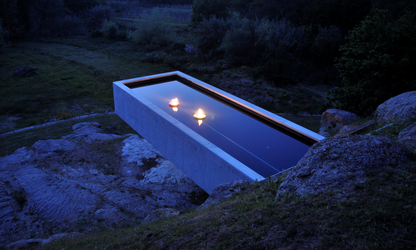 Flut Red  and Yellow fireplaces set up in outdoor suspended swimming pool with view on rocks and fields underneath. 