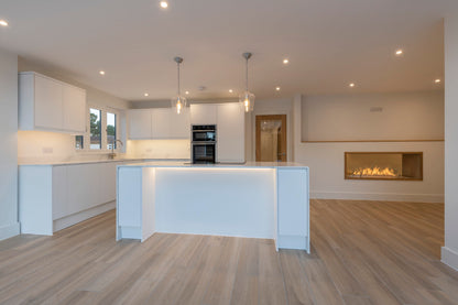 see-through fireplace in white kitchen and wooden floor