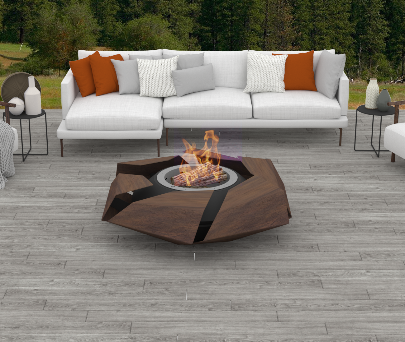 Stravaganza firepit with woodburner in rusted corten steel finish in stone-tiled patio with sofa and couches. A beautiful forest and the Alps are in the background.